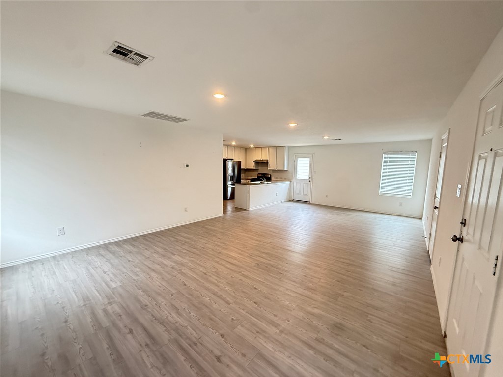 5863 Coahulia Ridge Seguin, TX 78155 - Photo 4 of 15 an empty room with wooden floor and a window