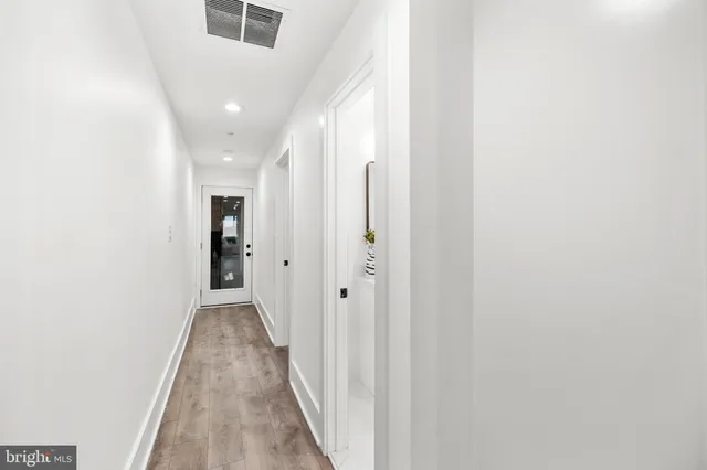 a view of a hallway with wooden floor