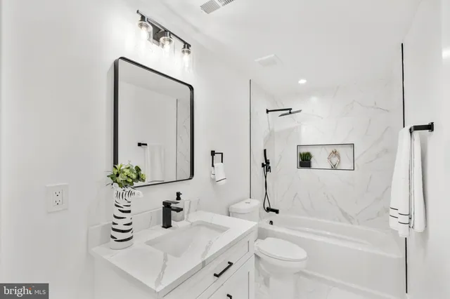 a bathroom with a bathtub shower sink and toilet