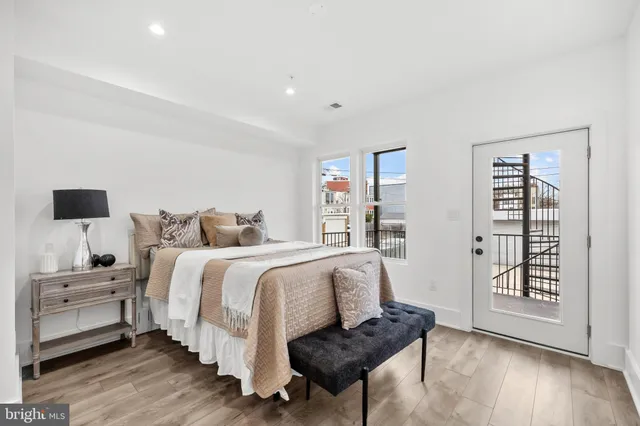 a spacious bedroom with a bed and wooden floor