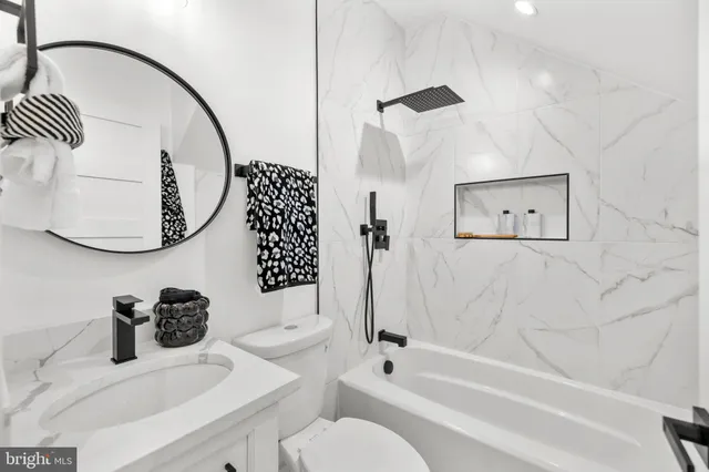 a bathroom with a sink a toilet and a mirror