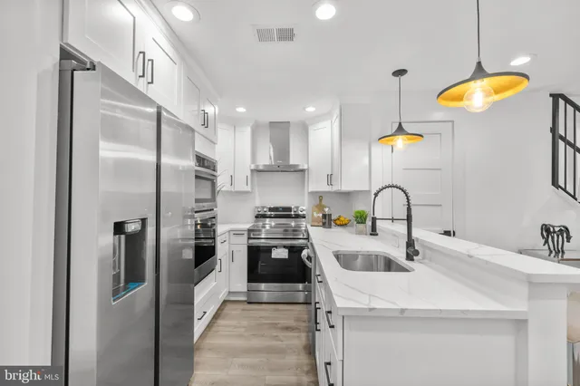 a kitchen with stainless steel appliances a refrigerator sink and stove