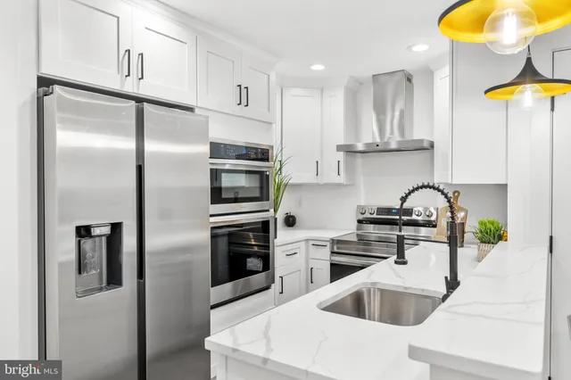 a kitchen with stainless steel appliances granite countertop a sink and a refrigerator