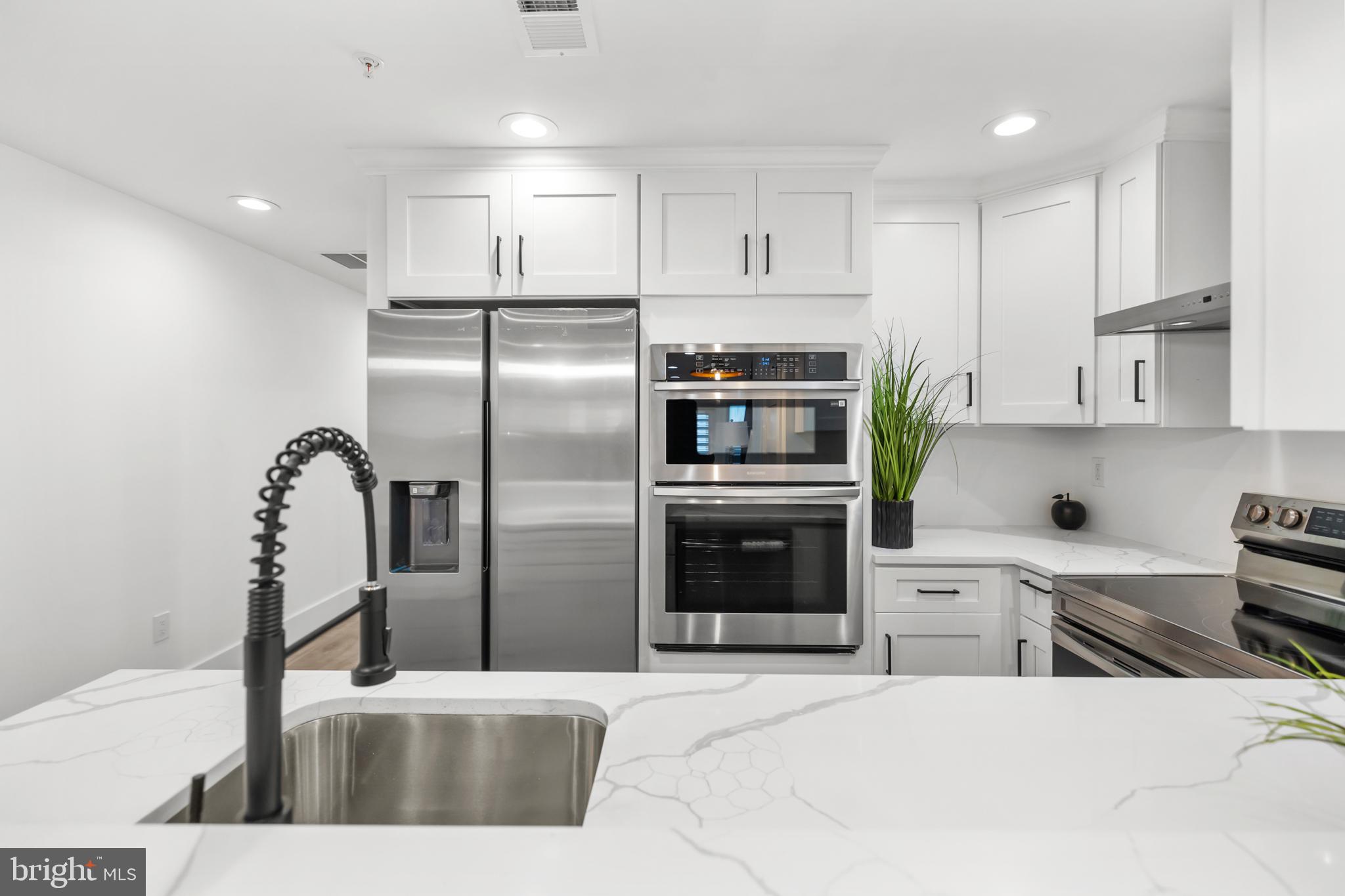 113 18th Street Southeast, Unit 1 Washington, DC 20003 - Photo 8 of 37 a kitchen with stainless steel appliances kitchen island granite countertop a refrigerator sink and stove