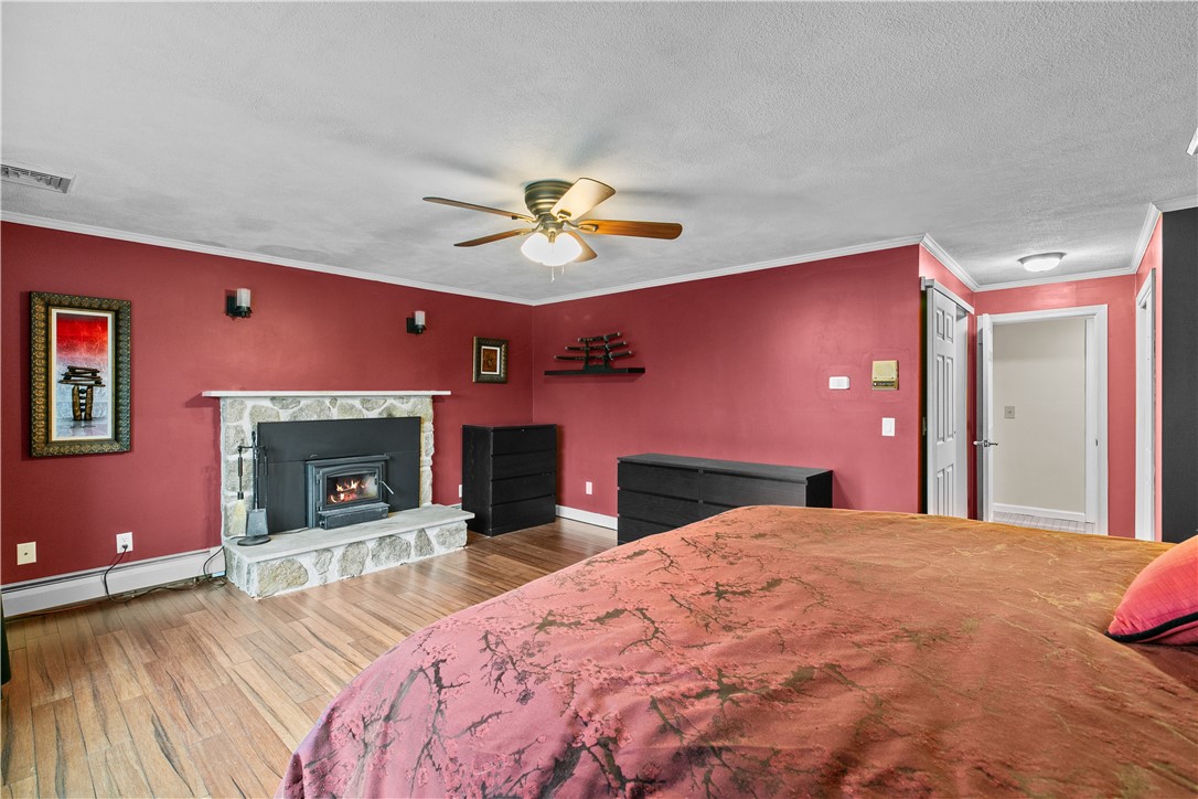 831 Crandall Road Tiverton, RI 02878 - Photo 25 of 50 Primary Bedroom with Wood Stove