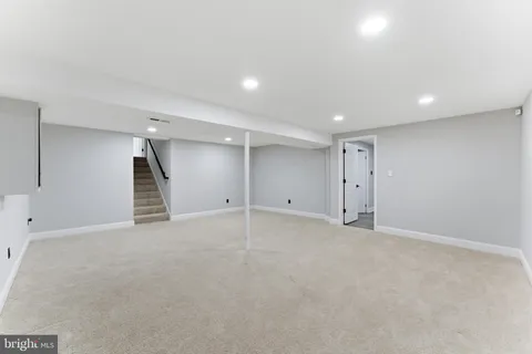 an empty room with white walls and refrigerator
