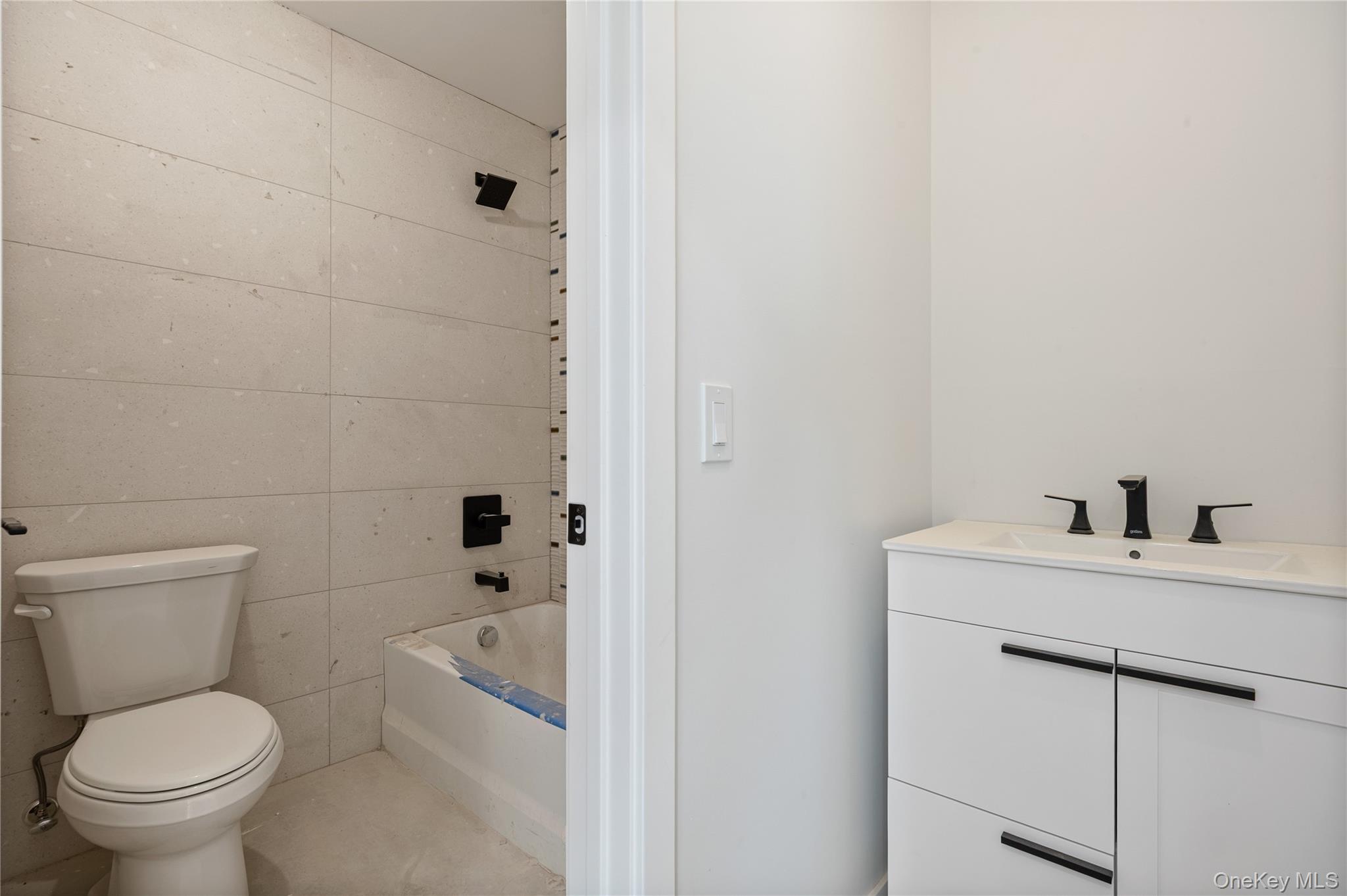 20 West Funston Avenue, Unit 212 Spring Valley, NY 10977 - Photo 23 of 34 a white toilet sitting next to a bathroom sink