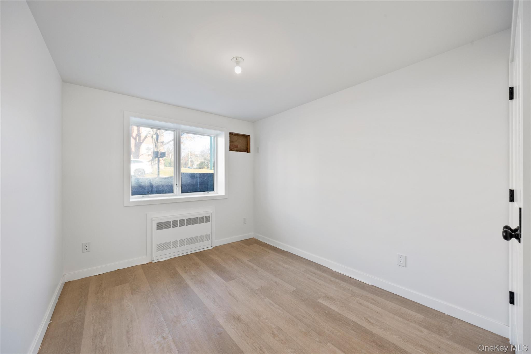 20 West Funston Avenue, Unit 212 Spring Valley, NY 10977 - Photo 30 of 34 an empty room with wooden floor and windows