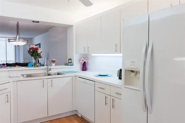 a kitchen with white cabinets and white appliances