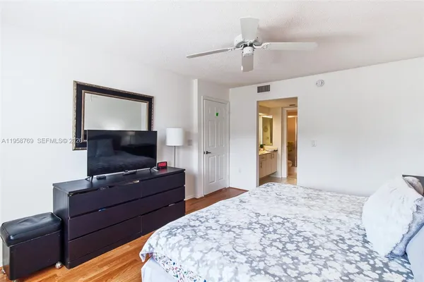 a bedroom with a large bed and a chandelier