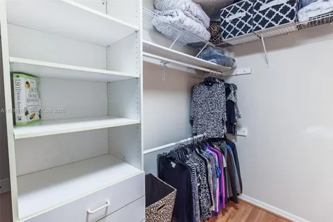 a view of walk in closet with clothes and shoes