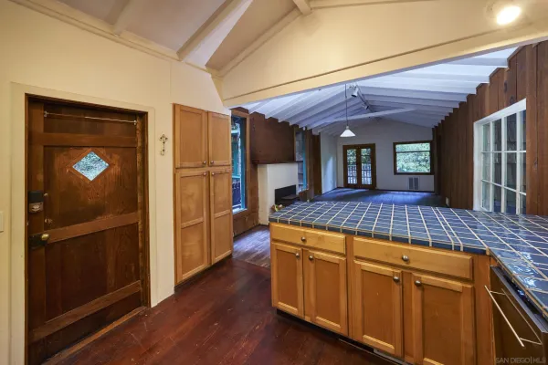 a kitchen with kitchen island wooden floors and refrigerator