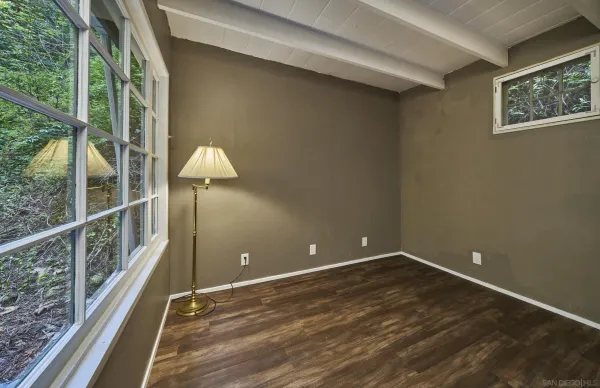 a view of empty room with a window and wooden floor