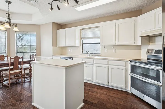 a kitchen with granite countertop white cabinets and white appliances