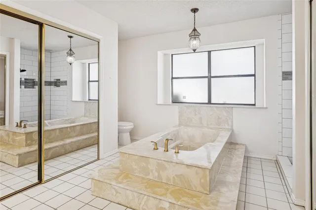 a bathroom with a tub sink and glass door shower