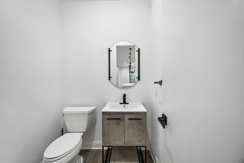 a bathroom with a toilet a sink and mirror