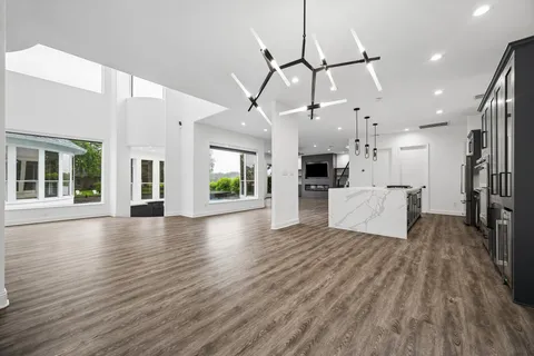 a view of a living room and kitchen with furniture wooden floor and a large window