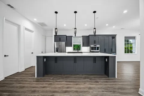 a kitchen with kitchen island a refrigerator and a counter top
