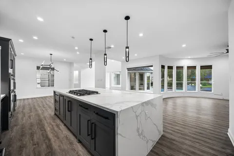a kitchen with stainless steel appliances granite countertop a stove and a wooden floors