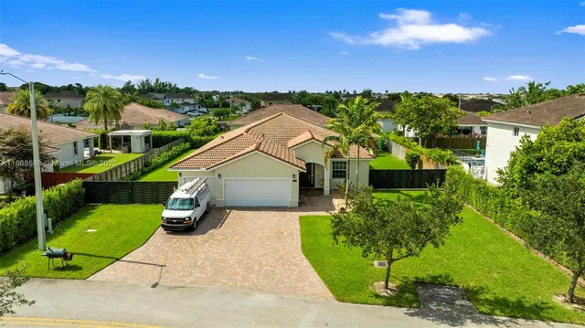 a view of a house with a yard and potted plants