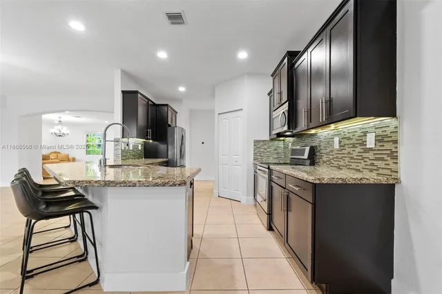 a kitchen with kitchen island granite countertop wooden cabinets and a sink