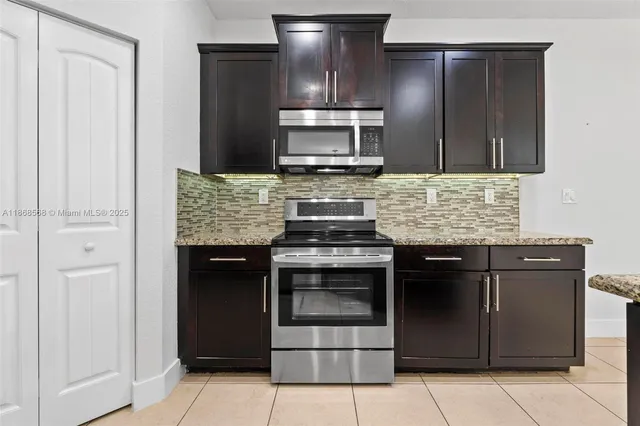 a kitchen with granite countertop a stove and a refrigerator
