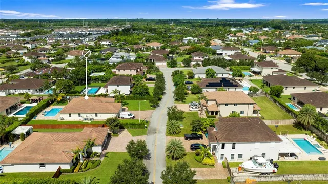 an aerial view of residential houses with outdoor space and swimming pool