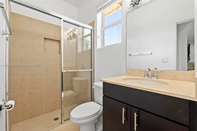 a bathroom with a sink toilet vanity and shower