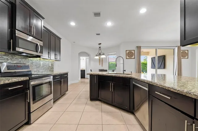 a kitchen with stainless steel appliances granite countertop a sink counter space cabinets and a counter top space