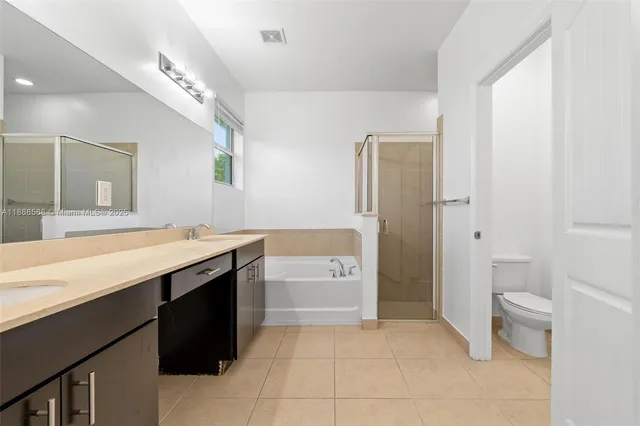 a spacious bathroom with a granite countertop sink a toilet and shower