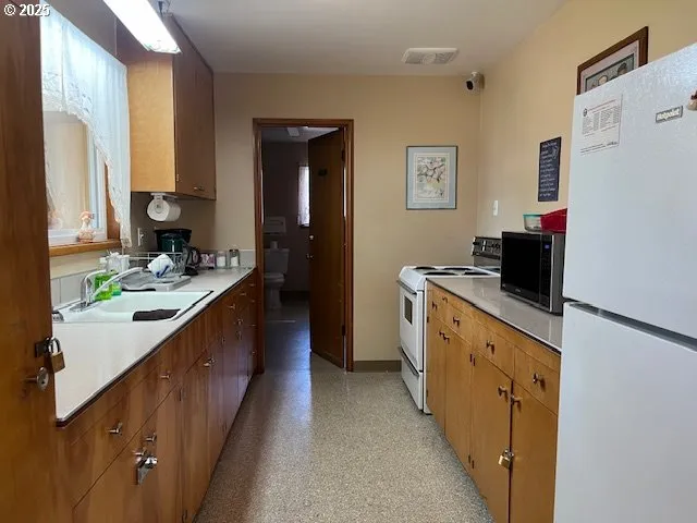 a kitchen with stainless steel appliances a refrigerator sink and white cabinets