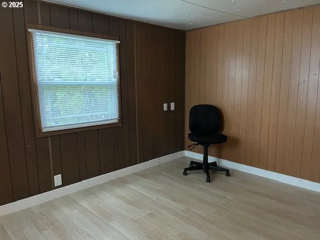 a view of a workspace room with wooden floor and windows
