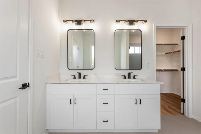 a bathroom with double vanity sinks and a mirror