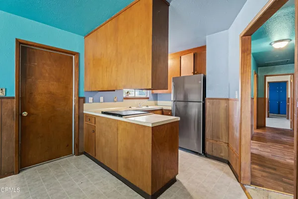 a kitchen that has a refrigerator and a stove in it