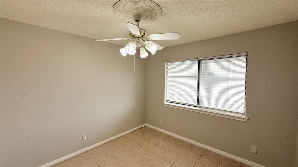 6108 Abrams Road, Unit 125 Dallas, TX 75231 - Photo 15 of 20 Room featuring a window with horizontal blinds, a ceiling fan with integrated lighting, and neutral wall paint
