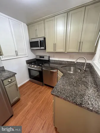 a kitchen with stainless steel appliances granite countertop a sink stove and microwave