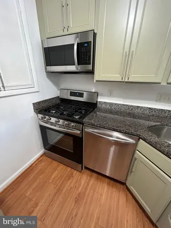 a kitchen with granite countertop a stove and a microwave