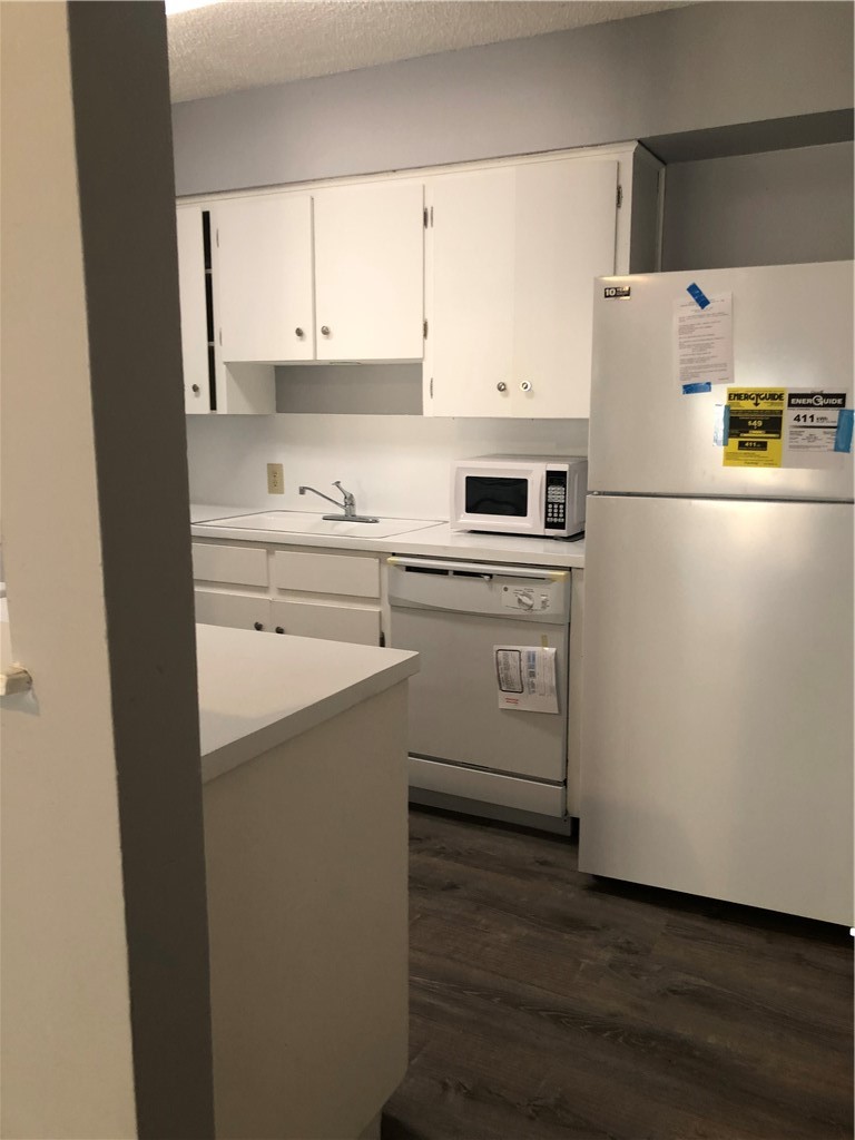 6502 South 1st Street, Unit 102 Austin, TX 78745 - Photo 11 of 26 a white refrigerator freezer sitting in a kitchen