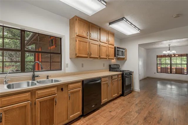 a kitchen with stainless steel appliances granite countertop a sink and a refrigerator
