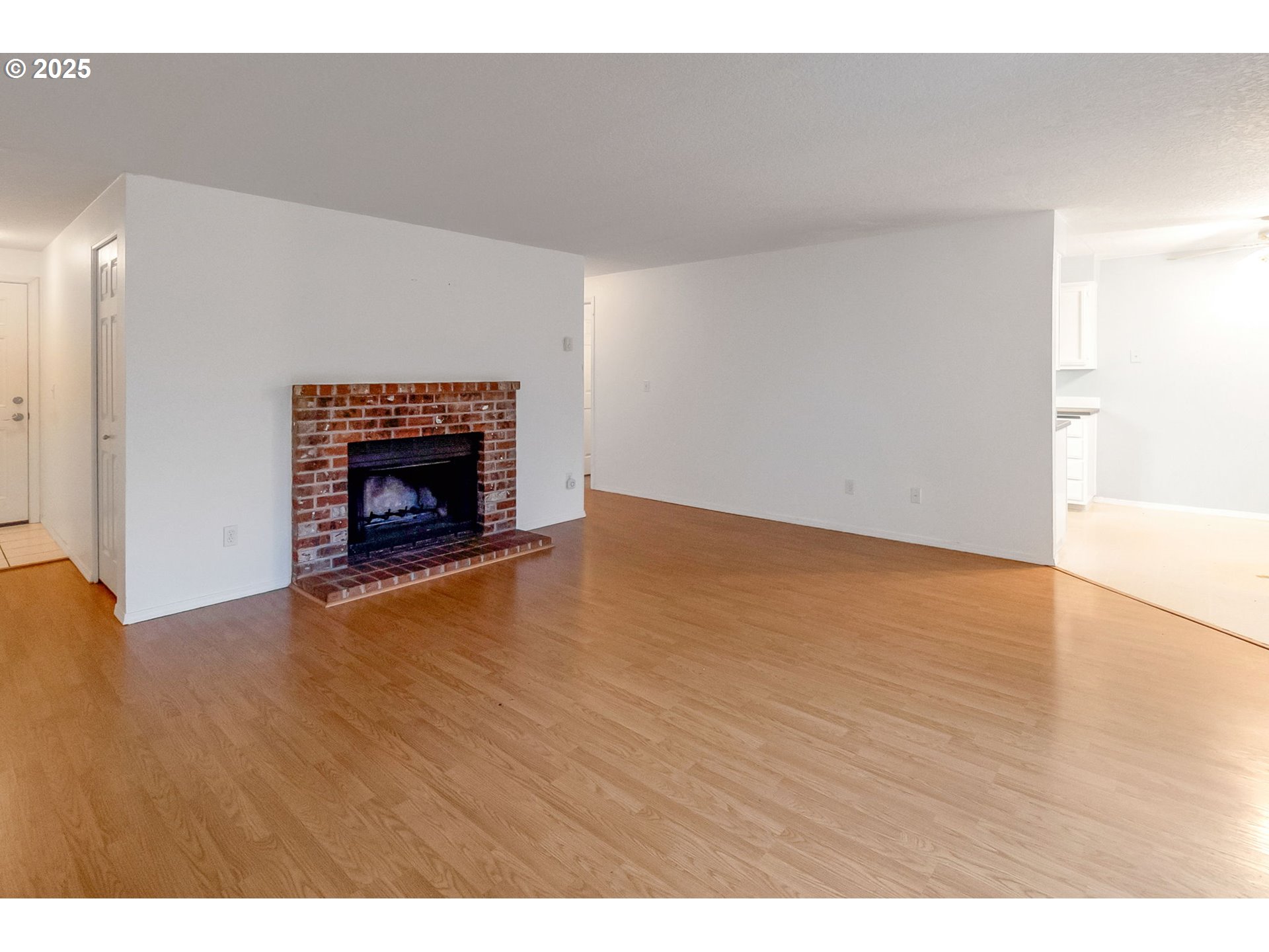 8524 Southwest Mohawk Street Tualatin, OR 97062 - Photo 3 of 30 a view of an empty room with wooden floor and a fireplace