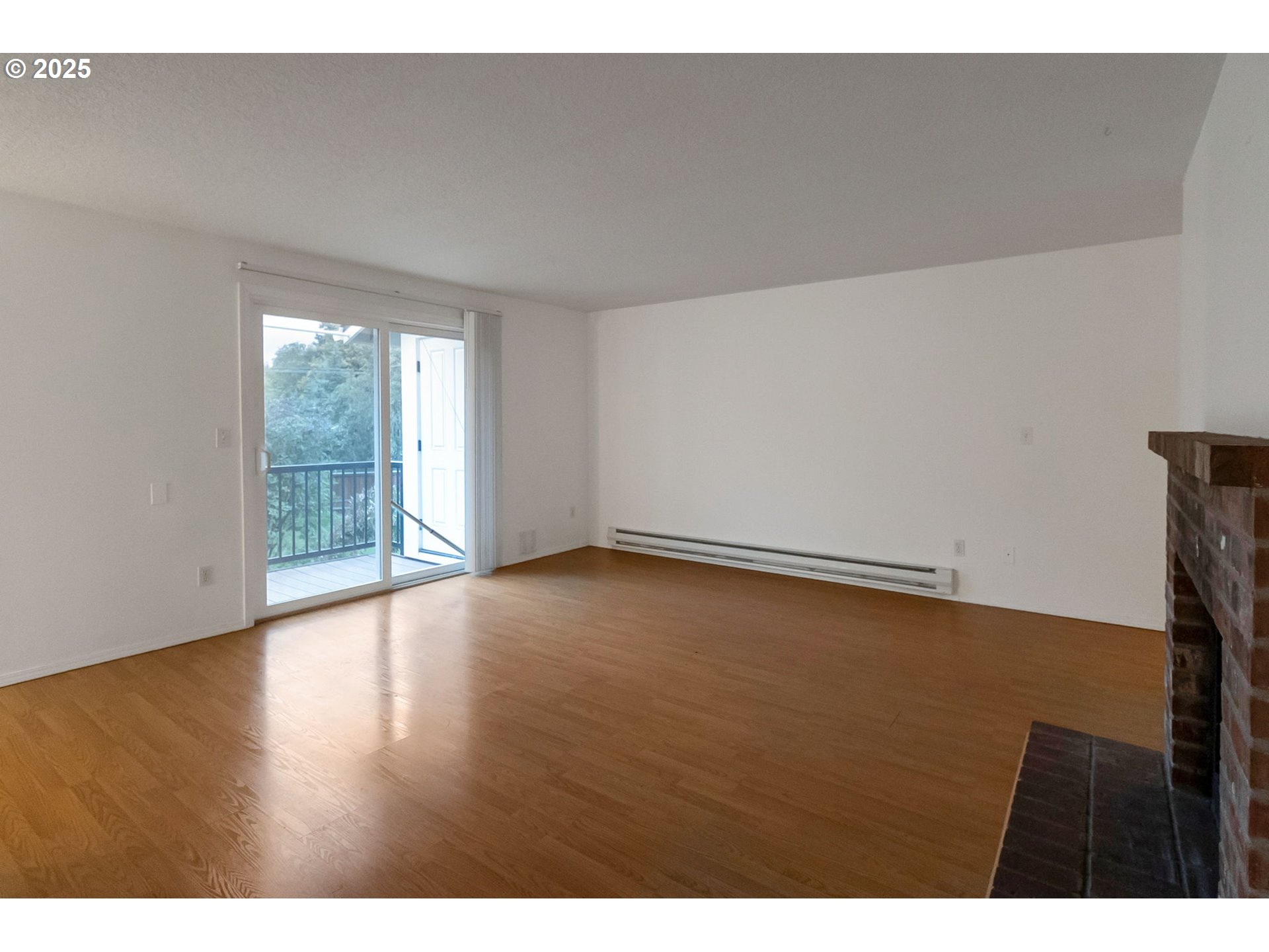8524 Southwest Mohawk Street Tualatin, OR 97062 - Photo 6 of 30 a view of an empty room with wooden floor and a window
