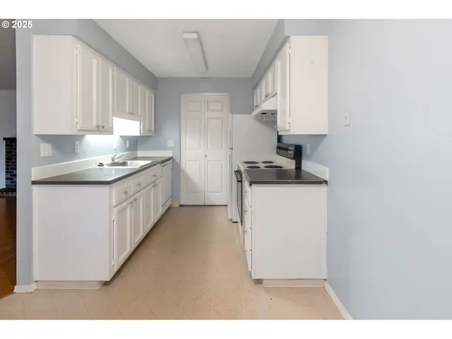a kitchen with a sink stove and cabinets