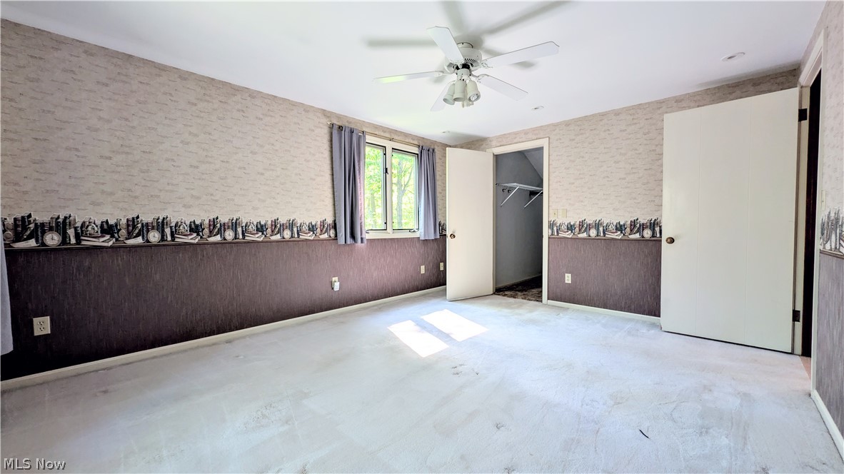 6409 Old Woods Road Ashtabula, OH 44004 - Photo 18 of 43 Carpeted interior space featuring a ceiling fan with integrated lighting, a window with curtains, and two interior doors