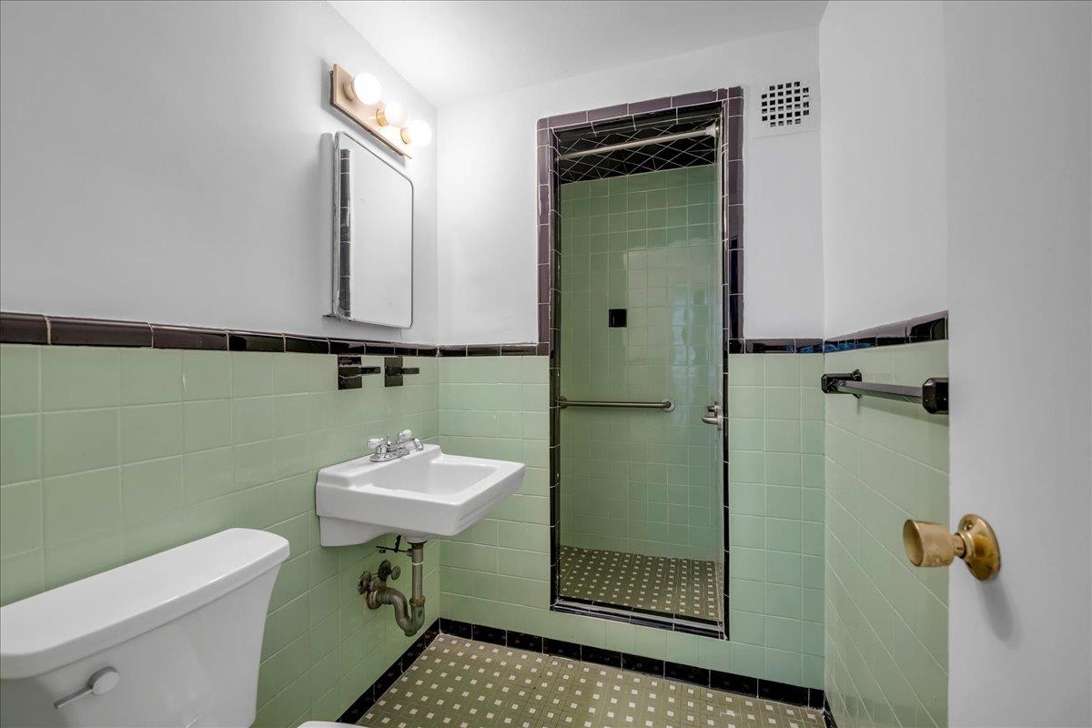 2727 Palisade Avenue, Unit 7B Bronx, NY 10463 - Photo 11 of 22 a bathroom with a sink toilet and a mirror