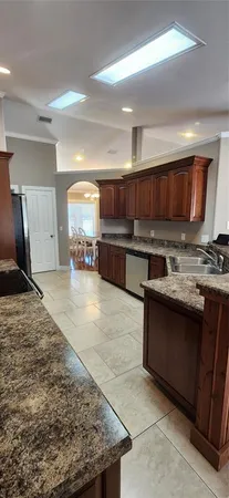 a kitchen with stainless steel appliances granite countertop a stove top oven a sink and dishwasher