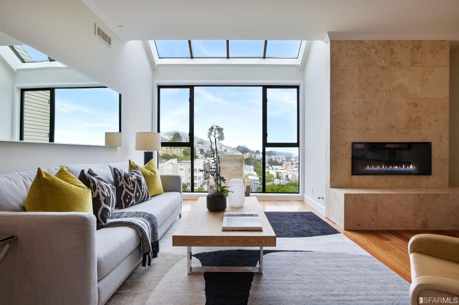 The sunken living room with fireplace looks out over Twin Peaks and downtown.