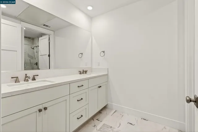 a bathroom with double sink and a mirror