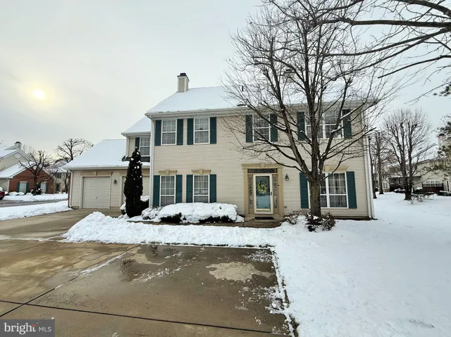 a front view of a house with a yard covered in snow