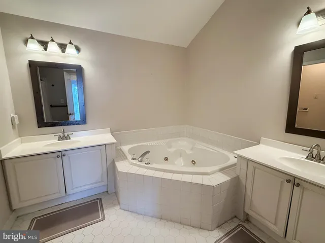 a bathroom with a bathtub sink and mirror