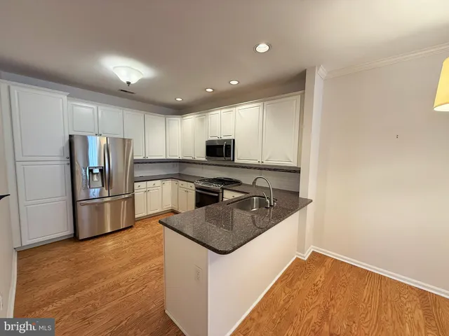 a kitchen with stainless steel appliances granite countertop a sink stove microwave and refrigerator
